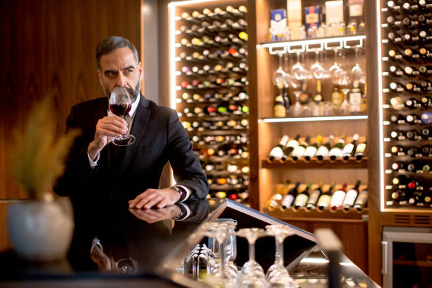 istock Handsome elegant businessman drinking red wine 882259026