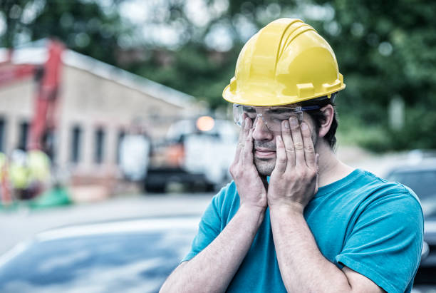 istock Tired Young Man Blue Collar Construction Worker Rubbing His Eyes 882262022