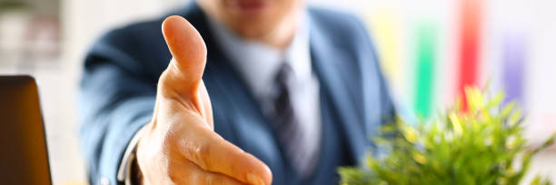 istock Man in suit and tie give hand as hello in office 882267520