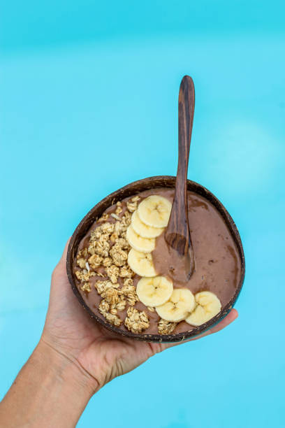 istock Banana chocolate mouse in coconut bowl by the pool 882272806