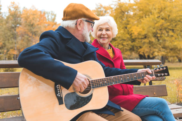 senior couple with guitar in park