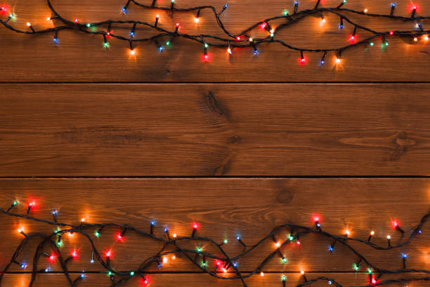 istock Christmas lights border on wood background 882273510