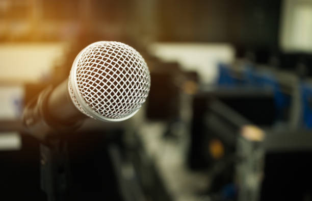 Microphone on abstract blurred of speech in seminar room or speaking conference hall light, computer bokeh background