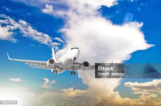 Airplane At Fly On The Sky With Cumulus Clouds Sunset Stock Photo - Download Image Now