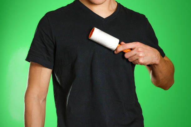 istock Guy brushing his black t-shirt from debris sticky roller 882273688