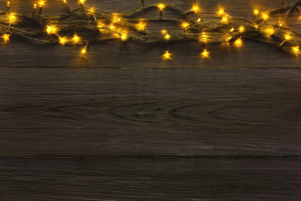 istock Christmas lights border on grey wooden background 882280210
