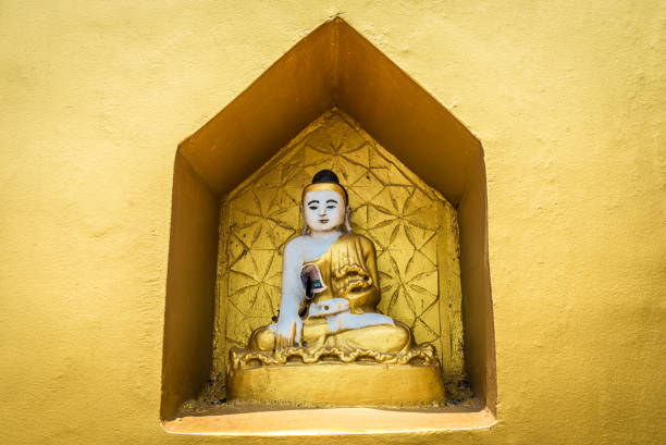 A small Buddhist altar with Buddha statues. Golden background in buddhist temple.