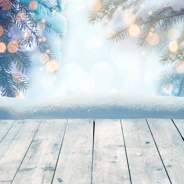 istock Winter background with snow-covered pine trees behind empty wooden planks 882291298