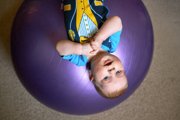 istock Little boy lies upside down on a fitball 882298714
