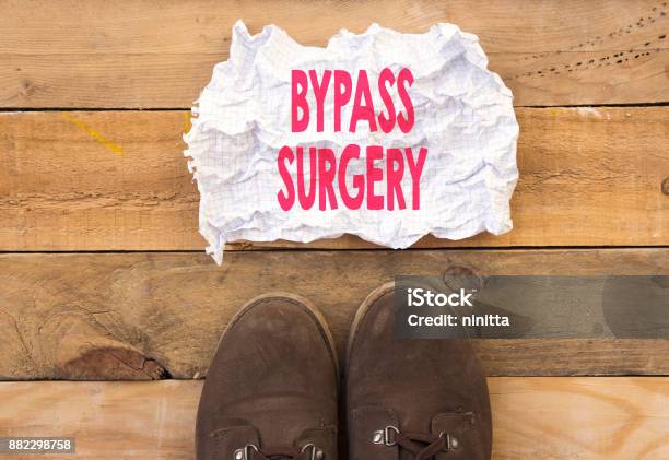 Person Stand Up On Wood And Need A Bypass Surgery Written In Crumpled And Crashed Paper Stock Photo - Download Image Now