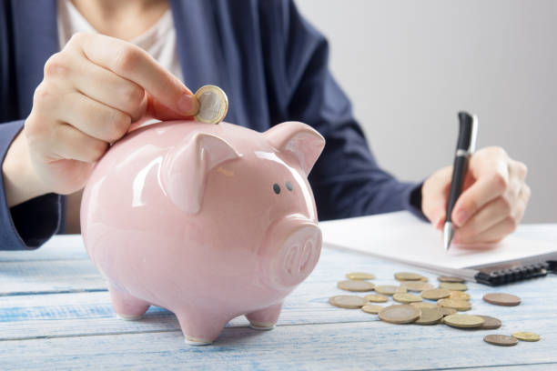 istock Hand putting coin into piggy bank closeup. selective focus 882299144