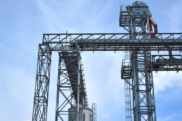 istock Fragment of metal grain elevator in facility with silos. 882303650