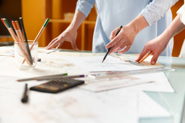 istock Interior designers working on hand drawings of  interior at work place 882310752
