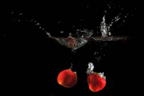 istock Strawberries splashing into water 882314618