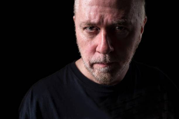 istock Serious middle aged man in black with beard stubble. 882314760