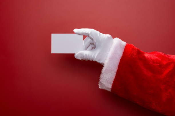 istock Santa Claus holding a white blank card good for test on red background 882314868