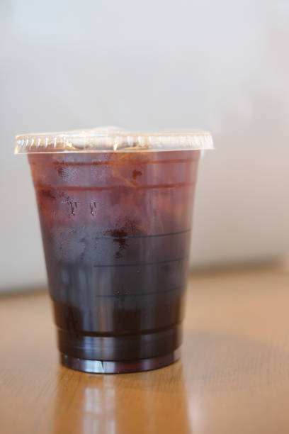 istock Iced black coffee on wooden table (selective focus) 882315020