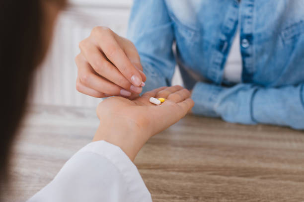 istock Nurse giving medicine while sitting at nursing home 882319250