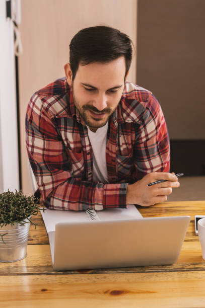 istock Handsome man working on laptop at home office. 882319798