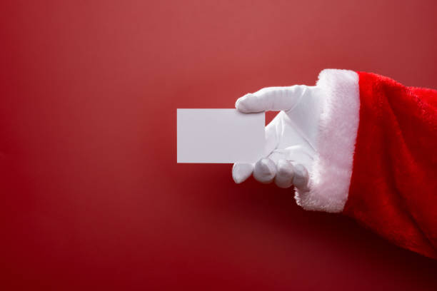 istock Santa Claus holding a white blank card good for test on red background 882323488