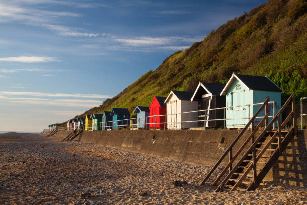 Beach huts Beach huts along side Cromer beach on a sunny day. east anglia stock pictures, royalty-free photos & images