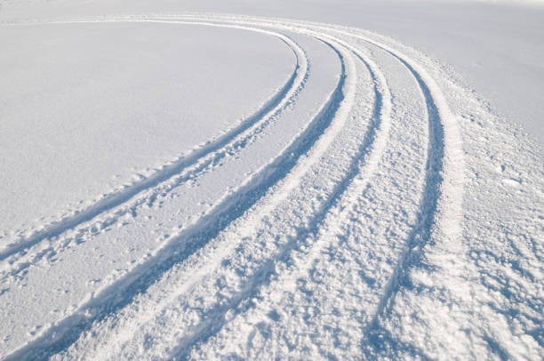 istock Car tire tracks in fresh snow 882329938
