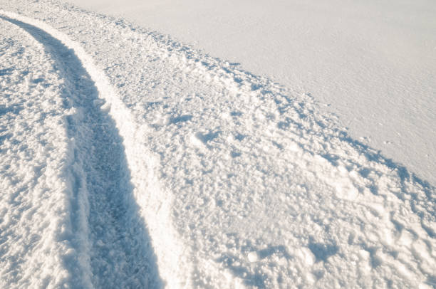 istock Car tire tracks in fresh snow 882330108