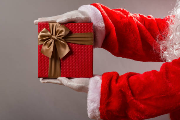 istock Santa Claus handing a gift box with brown bow 882331292