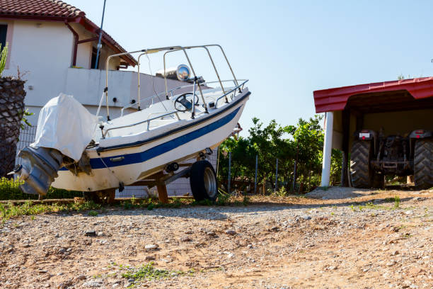 припаркованный небольшой катер на прицепе для перевозки во дворе - vehicle trailer nautical vessel towing yacht стоковые фото и изображения