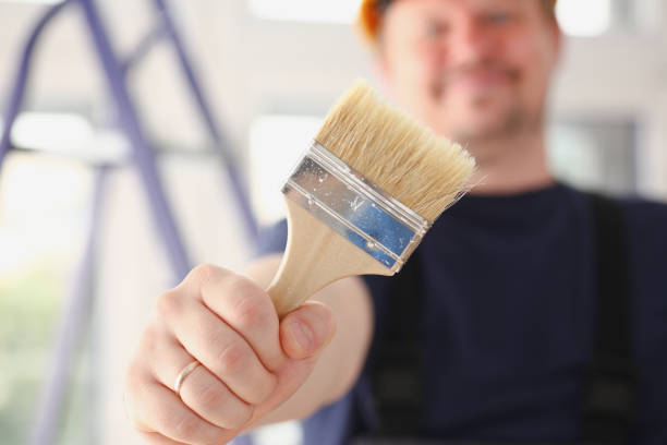 istock Arm of smiling worker hold brush closeup 882350234