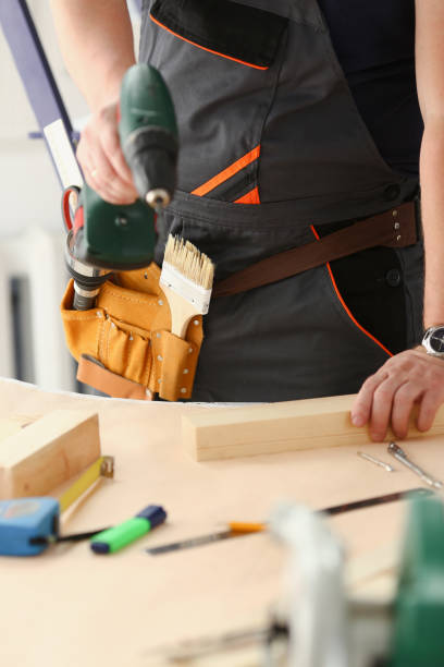 istock Arms of worker using electric drill 882350296