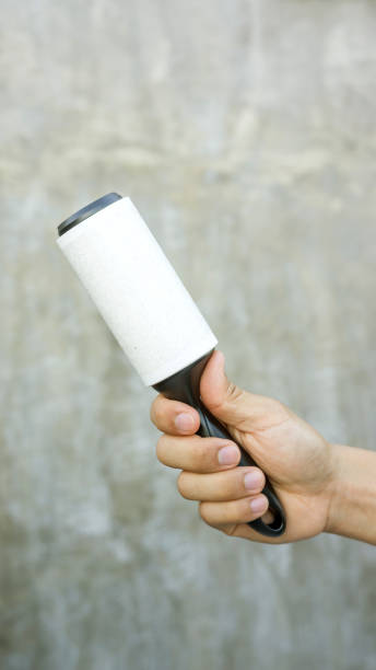 istock Man holding a hair removal roller on a gray background. 882350780