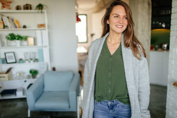 Portrait of a young woman Photo of a young, single woman who enjoys her cosy home and her single life cardigan sweater stock pictures, royalty-free photos & images