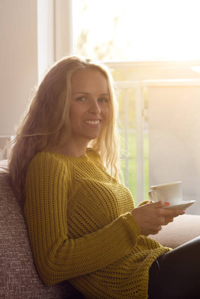 istock Woman drinking coffee beside window 882361304