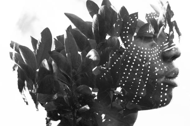 istock Double exposure of a dark skinned man with dreadlocks and closed eyes combined with a photograph of a beautiful lush plants in black and white 882367338