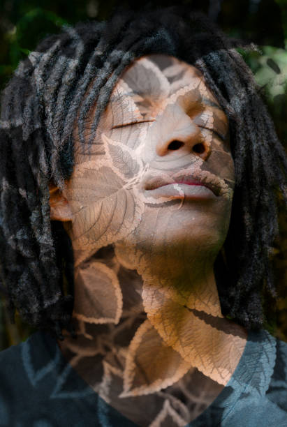 istock Double exposure of a dark skinned man with dreadlocks and closed eyes, combined with a beautiful texture of leaves 882367982