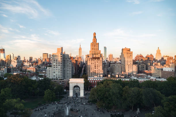 new york urban skyline bei sonnenuntergang - washington square triumphal arch stock-fotos und bilder