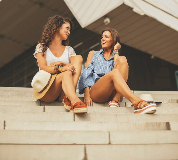 istock Two pretty girls sitting on staircase 882372972