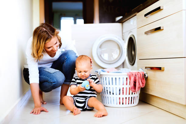 giovane madre con un bambino che fa i lavori domestici. - women smiling body cheerful foto e immagini stock