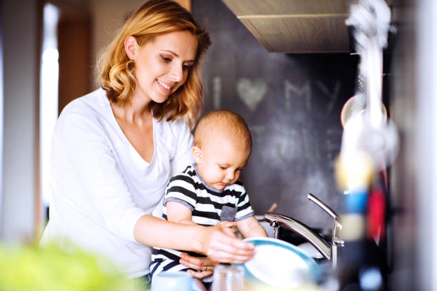 istock Young mother with a baby boy doing housework. 882378870