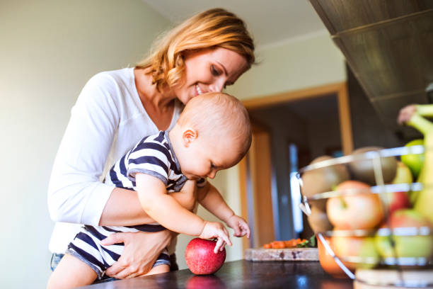 istock Young mother with a baby boy doing housework. 882378914