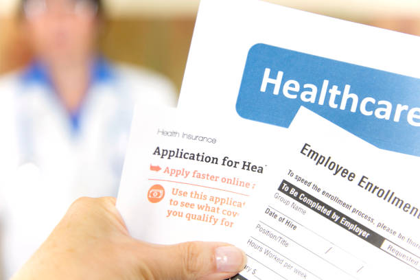 Open enrollment healthcare forms and medical doctor. Open enrollment healthcare benefits forms with a medical doctor in the background.  Healthcare remains an important topic around the world! enrollment stock pictures, royalty-free photos & images
