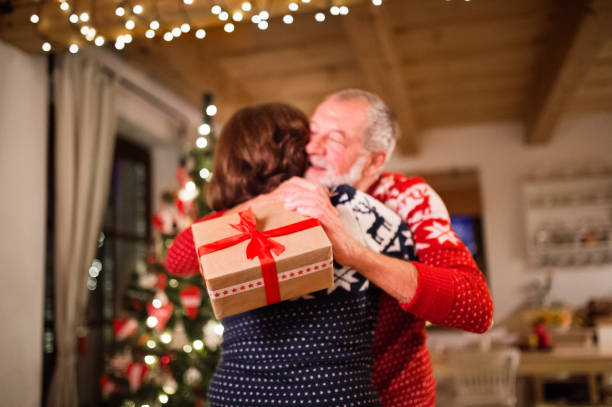 istock Senior couple exchanging presents at Christmas time. 882387382