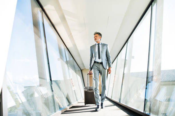 istock Mature businessman with suitcase travelling. 882392670