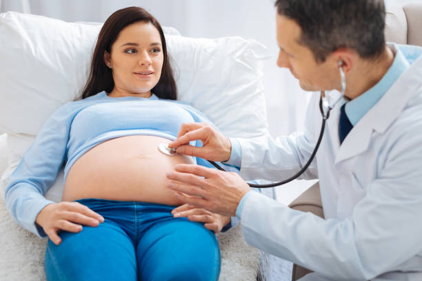 istock Cheerful pregnancy lying on the couch in clinic 882397164