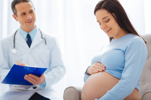 istock Positive brunette looking at her big tummy 882397910