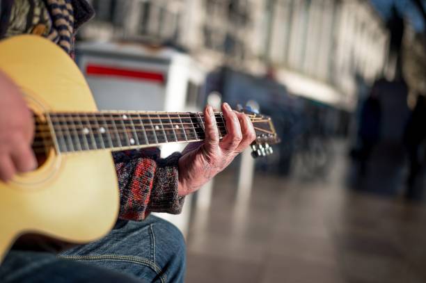 istock Street musician or busker playing guitar. 882405310