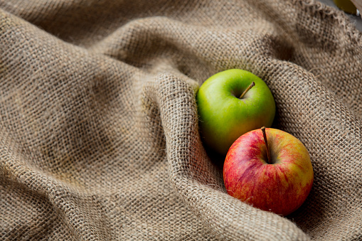 Two autumn apples on jute sack background. Season image