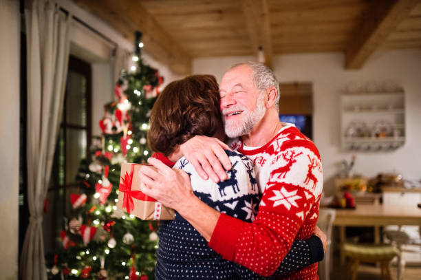istock Senior couple exchanging presents at Christmas time. 882415568