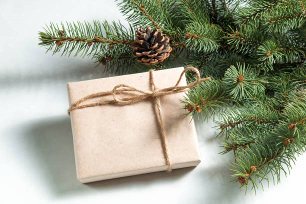 istock New year, Christmas gift paper tied to a string under fir branch with cone 882425278